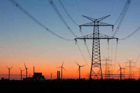 Wind turbines and transmission towers at sunset